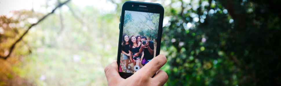 trabalhar viajando como influenciador digital: um celular com vários amigos tirando uma foto