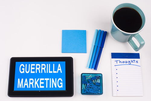 Imagen de materiales de escritorio y en la table la frase marketing de guerrilla.