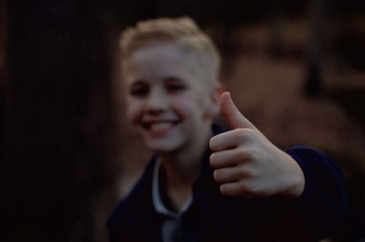 Imagen de niño levantando el dedo indice mostrando felicidad y confianza