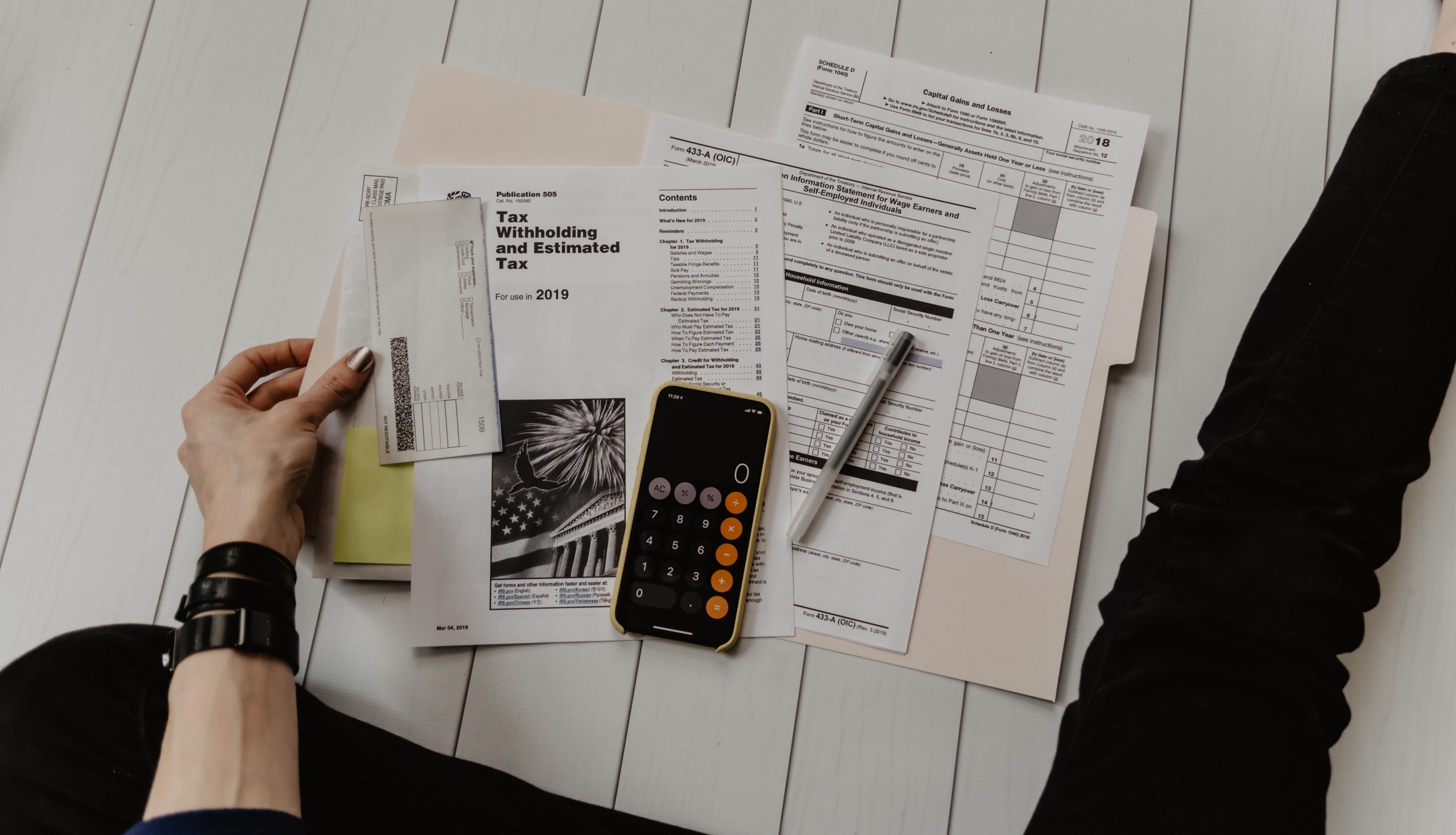 Imagen que muestra varias facturas por pagar, una calculadora y un lapicero representando los indicadores financieros de endeudamiento
