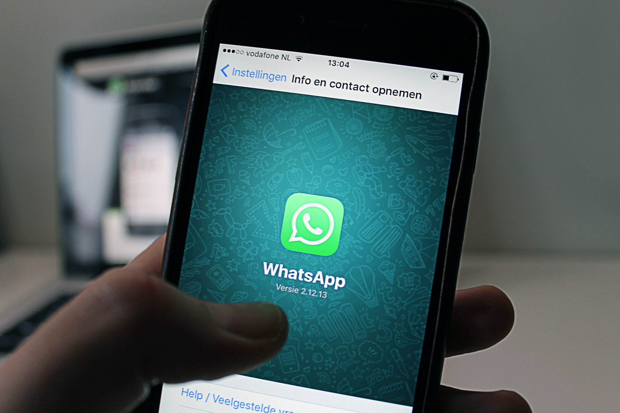 Redes sociales más usadas: Whatsapp se muestra el logo de Whatsapp dentro de una pantalla de un smartphone y un pulgar manipulando la pantalla