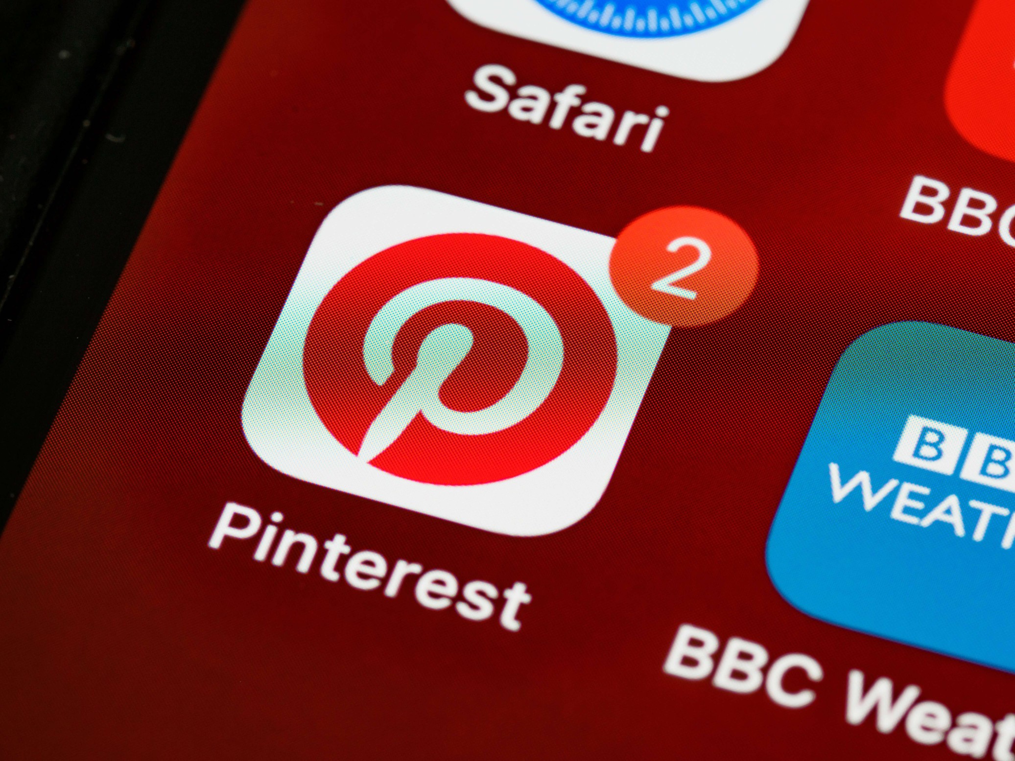 Ilustración del logotipo de Pinterest con dos notificaciones dentro de un smartphone
