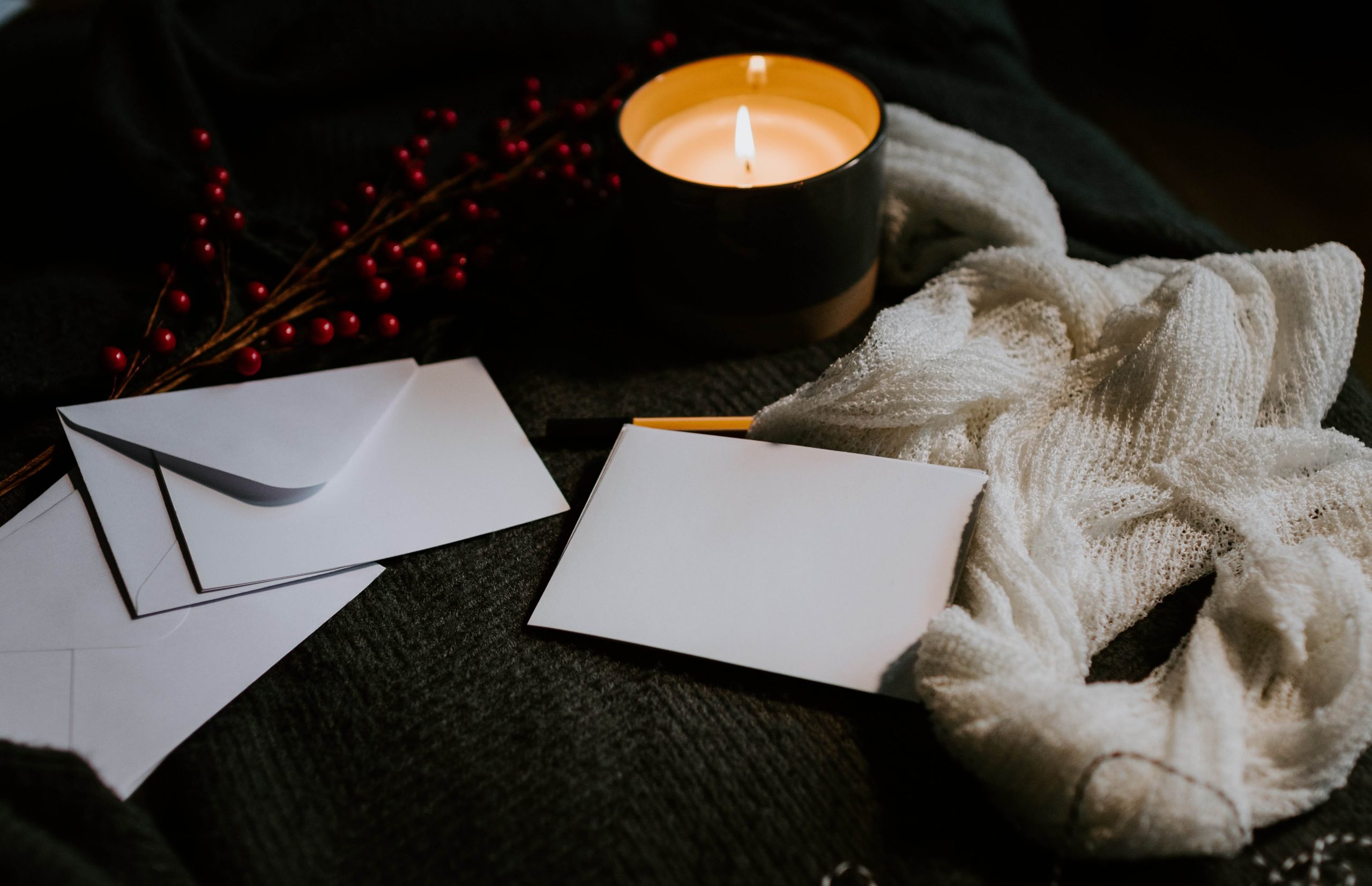 Image of letters and a lit candle on a cozy blanket