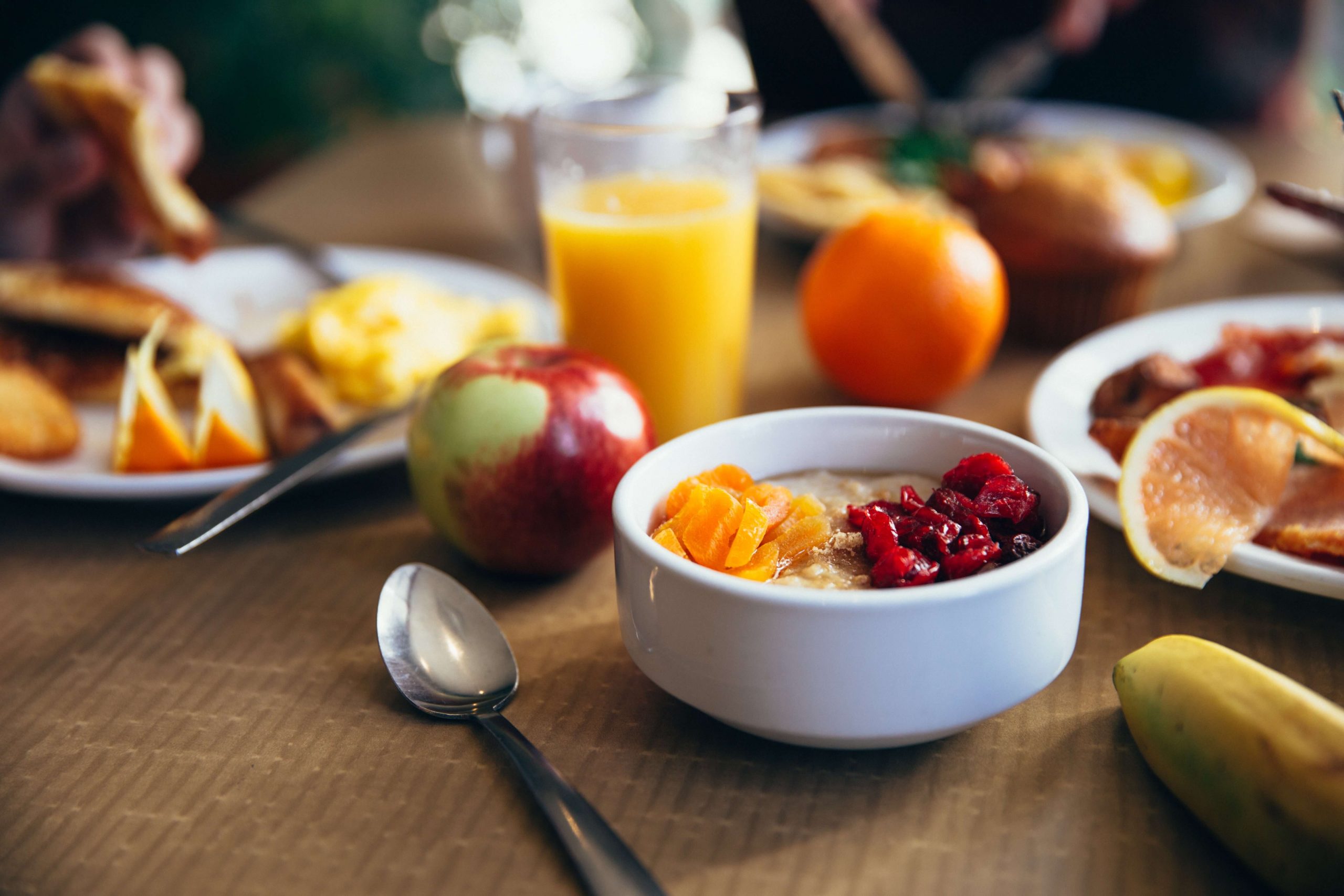 Imagen de una mesa con el desayuno servido, se pueden ver cereales, jugos y frutas. Uno de los regalos para novios preferidos por las personas.
