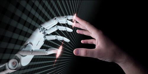 Imagen de dos manos, una robótica y la otra humana, representando a un desarrollador de inteligencia artificial y a su creación.