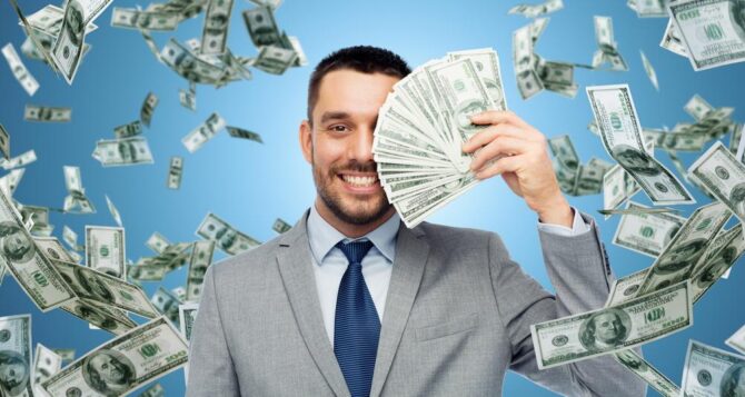 imagens chamativas - foto de um homem segurando notas de dinheiro enquanto outras notas caem atrás dele