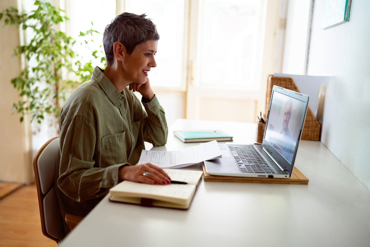 Mulher seguindo cursos online em seu laptop em casa
