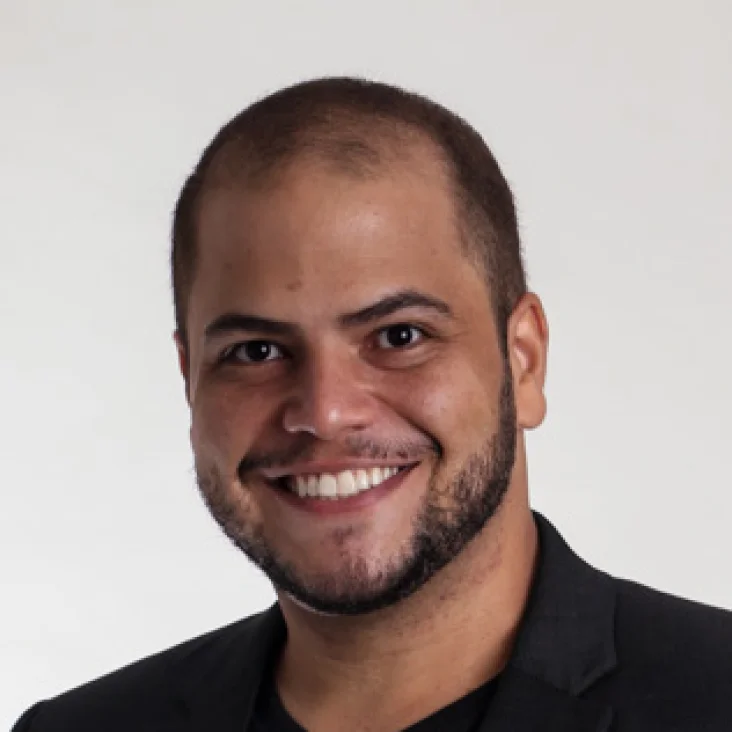 Hands typing at a laptop. On the screen, there is a page showing Hotmart Marketplace with courses to buy.