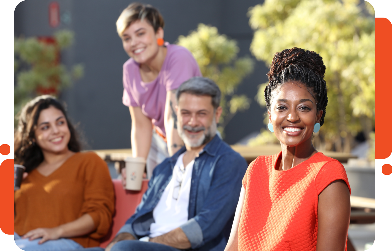 Black woman with braided hair in a bun wearing an orange t-shirt and smiling.