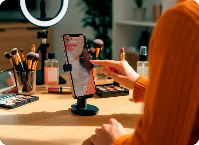 Creator grava conteúdo de beleza com smartphone, representando uma influencer criando vídeos para gerar autoridade e divulgar seu negócio digital.