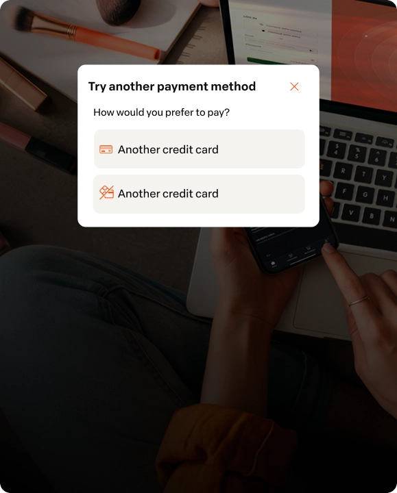 Mobile screen displaying payment options such as credit card, online card, and installment boleto, with a person using the phone at a wooden table